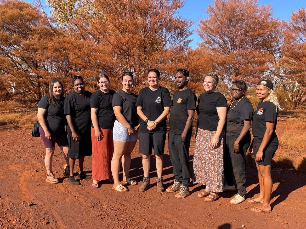 Graduation group photo of participants in Karijini with red trees and red dirt